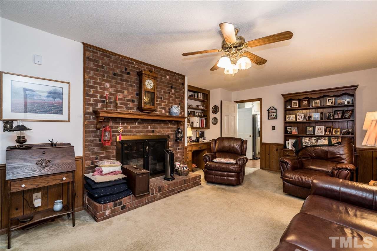 7301 Fiesta Way Raleigh, NC 27615 - Photo 9 of 25 a living room with furniture a fireplace and a ceiling fan