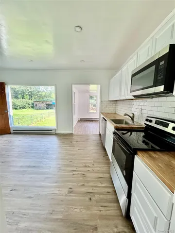 a kitchen with stainless steel appliances a stove microwave and sink