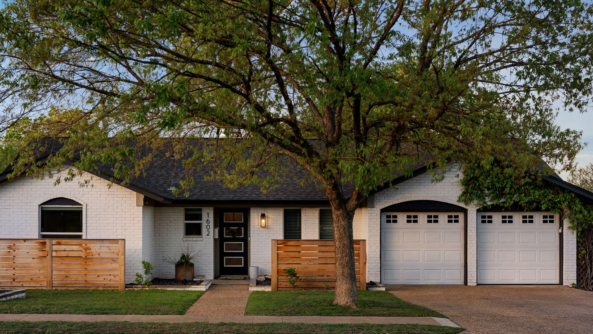 View of front of property with an attached garage, concrete driveway, and brick siding