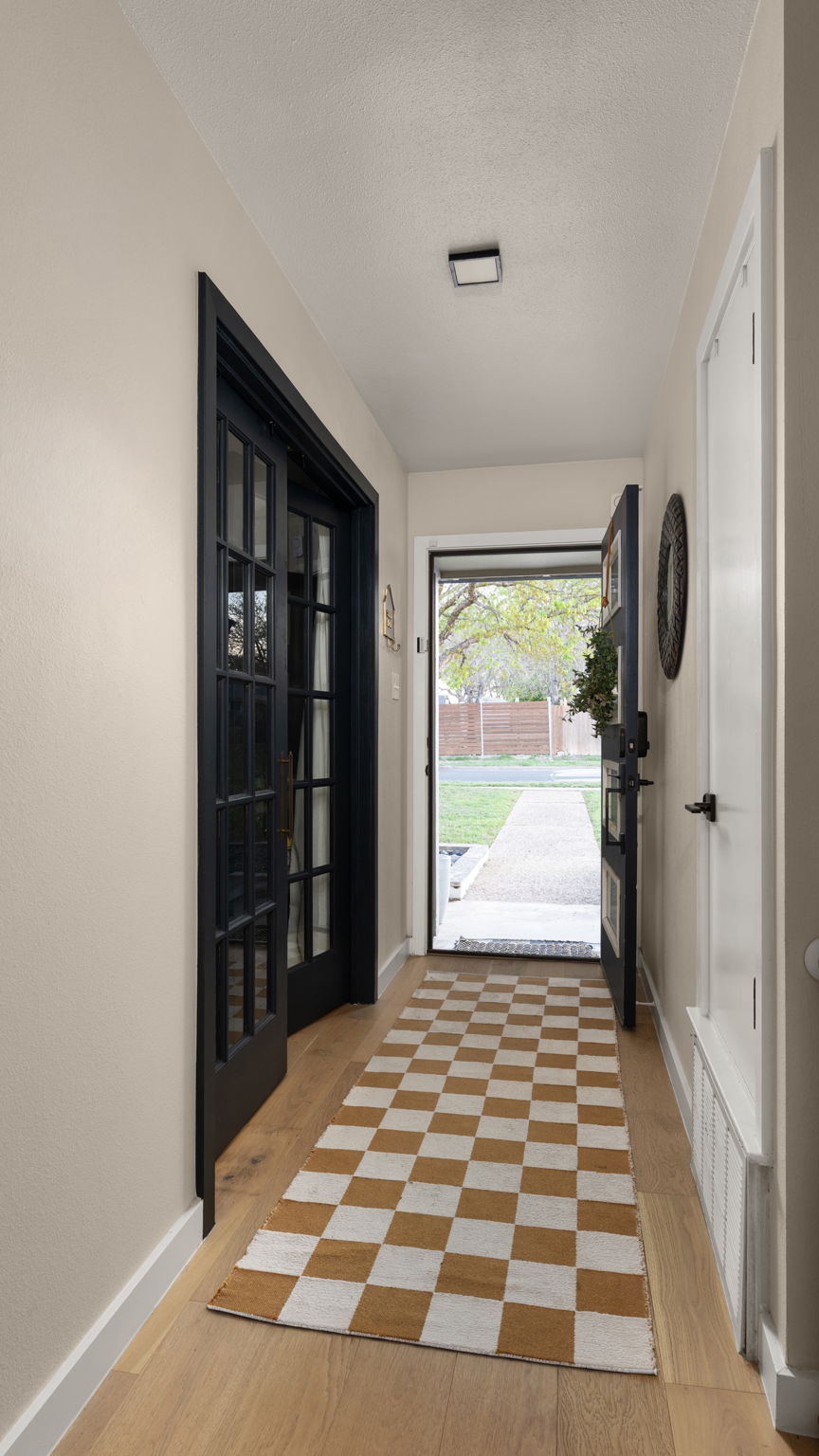 1602 Thornridge Road Austin, TX 78758 - Photo 11 of 39 Doorway to outside featuring wood finished floors and a textured ceiling