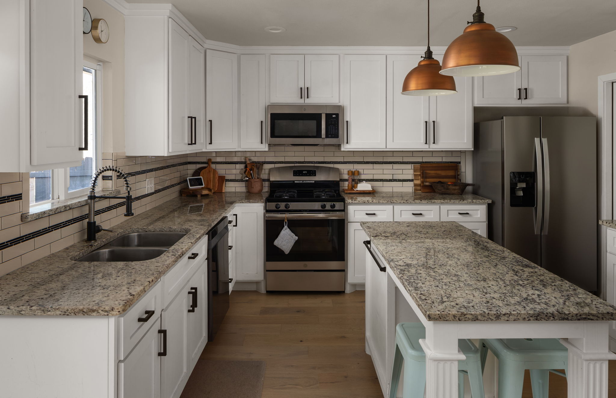 1602 Thornridge Road Austin, TX 78758 - Photo 19 of 39 Kitchen with stainless steel appliances, white cabinets, light stone counters, dark wood-style floors, and decorative backsplash