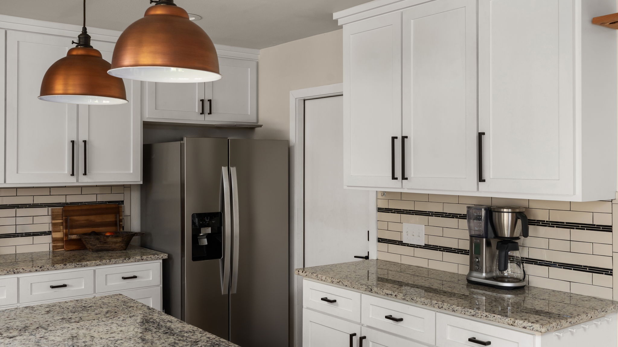 1602 Thornridge Road Austin, TX 78758 - Photo 21 of 39 Kitchen featuring light stone counters, stainless steel refrigerator with ice dispenser, backsplash, and white cabinets