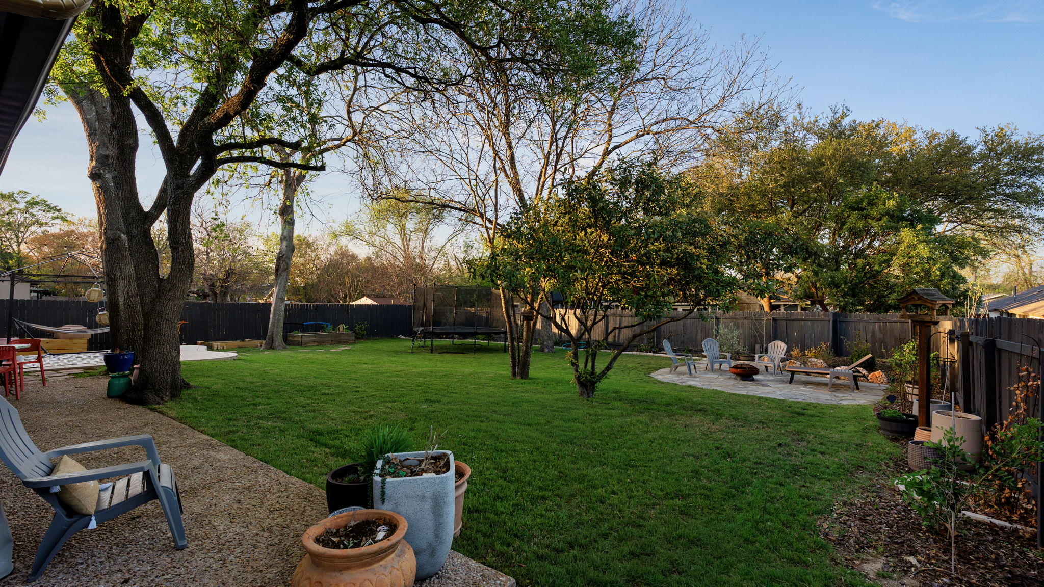 1602 Thornridge Road Austin, TX 78758 - Photo 30 of 39 Fenced backyard featuring a patio, a trampoline, and an outdoor fire pit