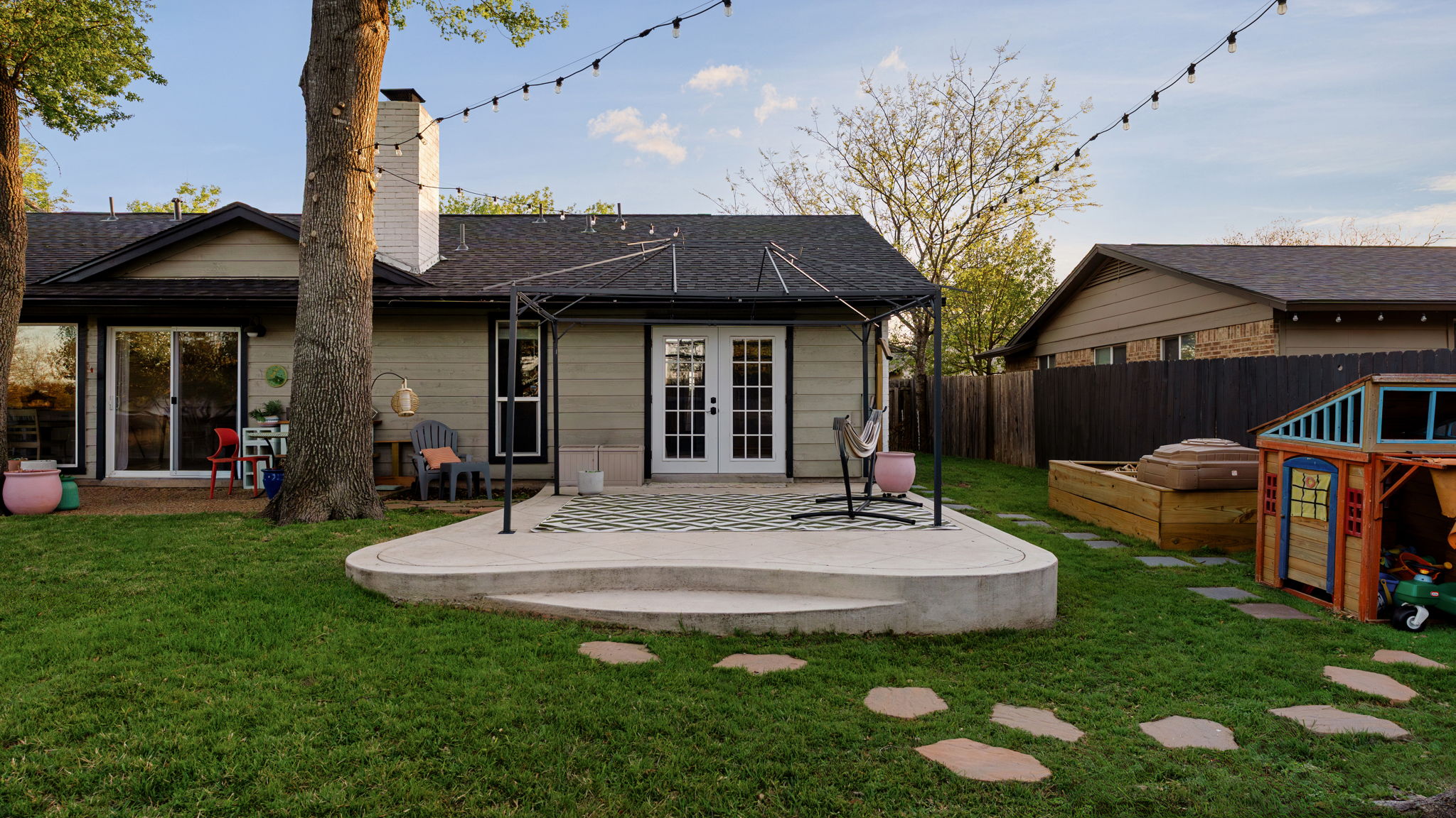 1602 Thornridge Road Austin, TX 78758 - Photo 31 of 39 Rear view of house featuring french doors, a patio area, a chimney, a vegetable garden, and a shingled roof