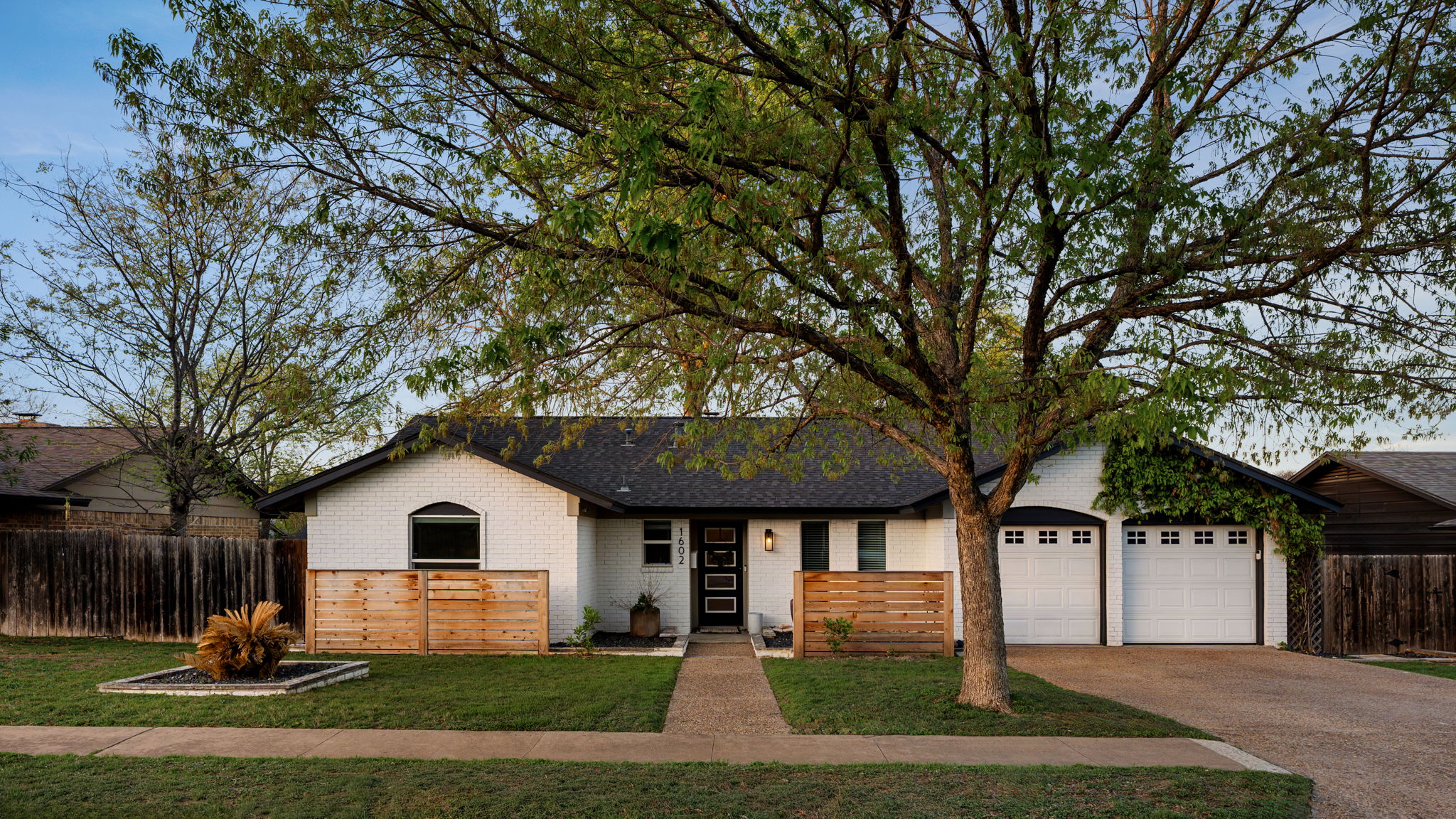 1602 Thornridge Road Austin, TX 78758 - Photo 7 of 39 Ranch-style house featuring brick siding, a garage, and driveway
