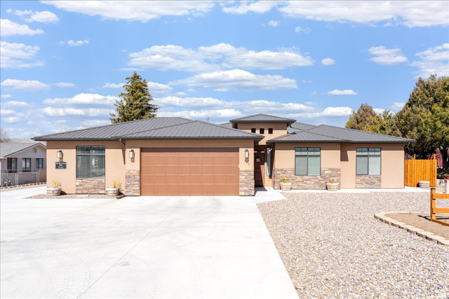 357 East Main Street Enterprise, UT 84725 - Photo 2 of 71 Prairie-style home with a garage, stucco siding, driveway, and stone siding