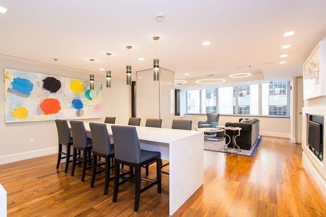 a living room with furniture a fireplace and a dining table with wooden floor