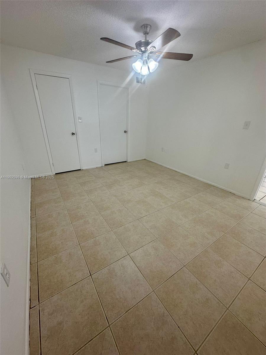 10581 Southwest 155th Court, Unit 1214 Miami, FL 33196 - Photo 14 of 35 a view of an empty room with a chandelier fan