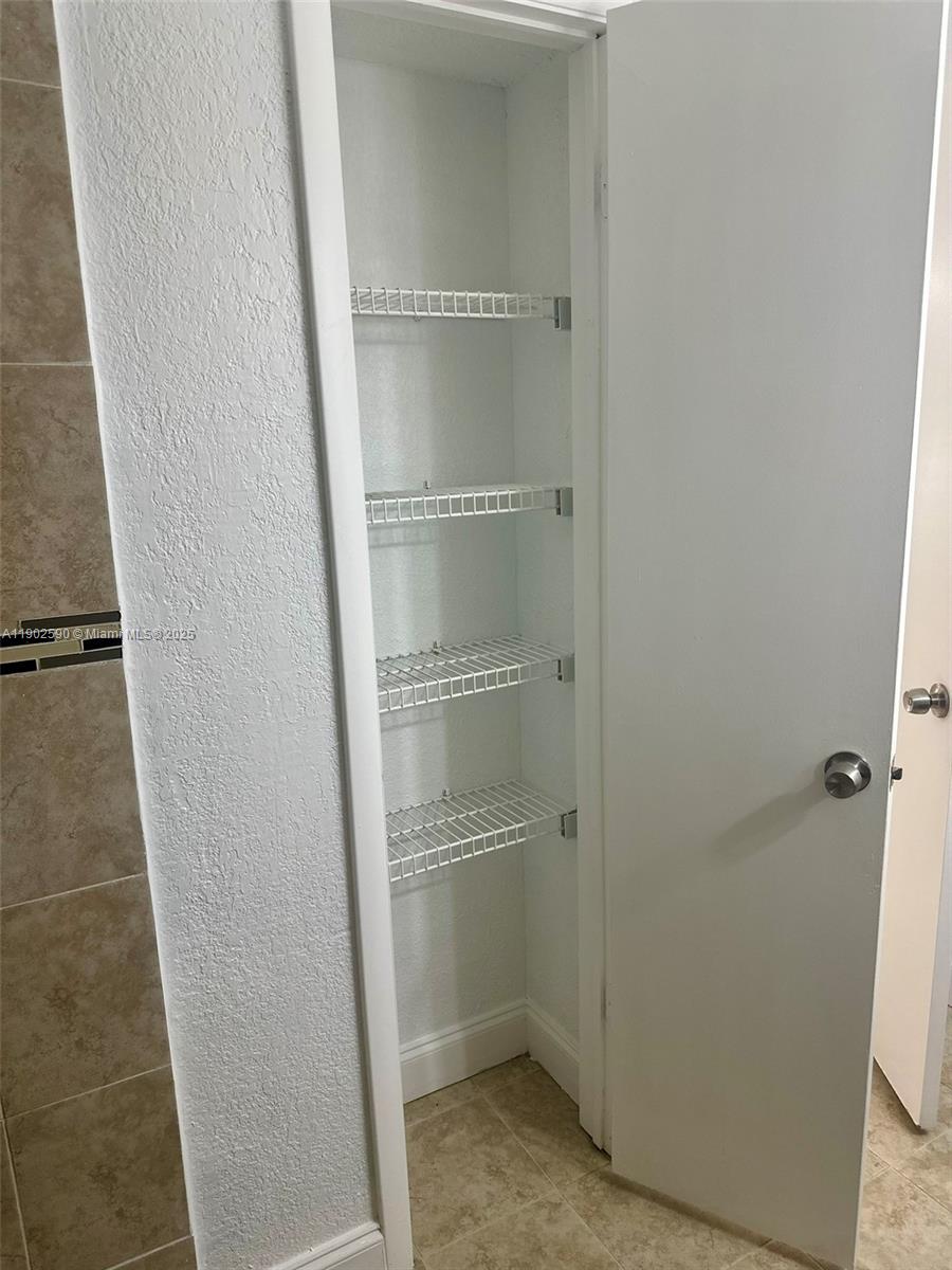 10581 Southwest 155th Court, Unit 1214 Miami, FL 33196 - Photo 18 of 35 a view of walk in closet with empty racks