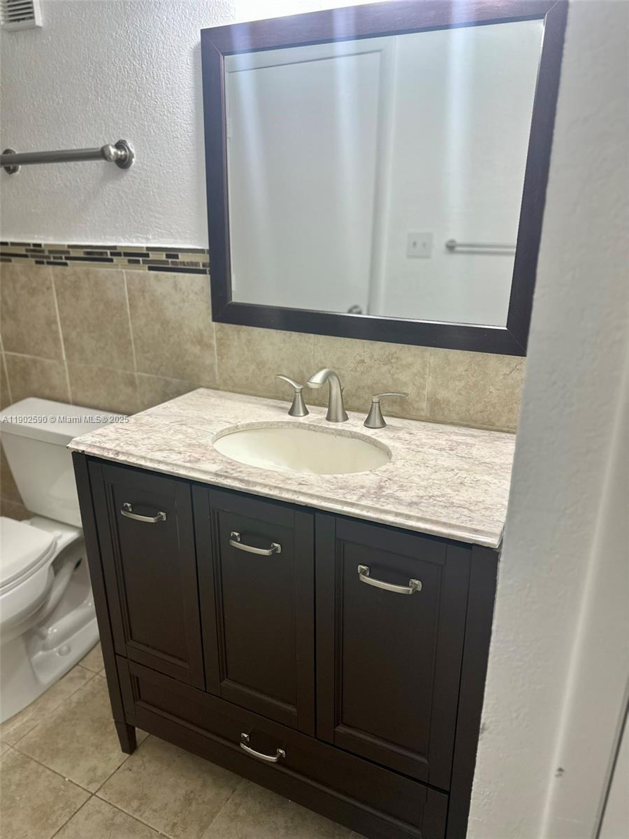 10581 Southwest 155th Court, Unit 1214 Miami, FL 33196 - Photo 21 of 35 a bathroom with a granite countertop sink and a mirror