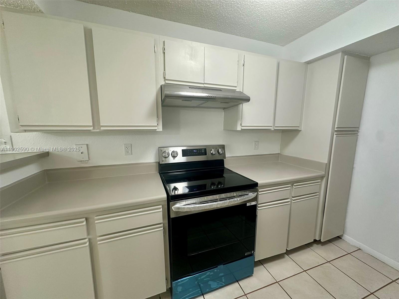 10581 Southwest 155th Court, Unit 1214 Miami, FL 33196 - Photo 10 of 35 a kitchen with white cabinets and appliances