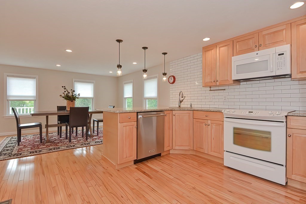 3 Zina Road Hudson, MA 01749 - Photo 11 of 41 a kitchen with stainless steel appliances granite countertop hardwood floor sink stove dining table and chairs