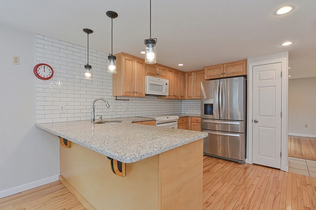 3 Zina Road Hudson, MA 01749 - Photo 9 of 41 a kitchen with stainless steel appliances granite countertop a sink a refrigerator and a stove
