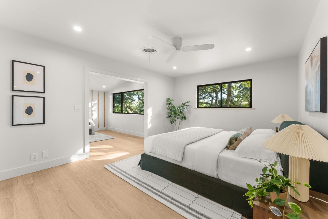 8717 South View Road Austin, TX 78737 - Photo 12 of 38 a bedroom with a large bed and a wooden floor