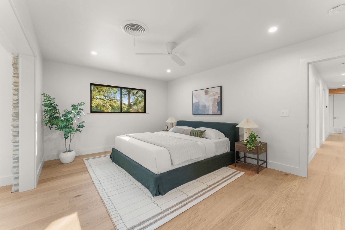 8717 South View Road Austin, TX 78737 - Photo 13 of 38 a bedroom with a large bed and a potted plant