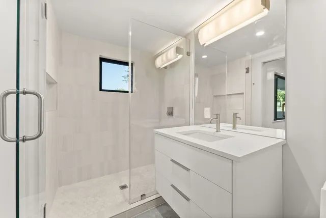 a bathroom with a sink a shower and a mirror