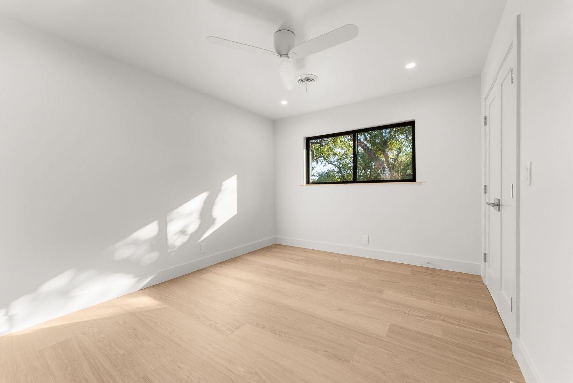 8717 South View Road Austin, TX 78737 - Photo 23 of 38 an empty room with windows & fan