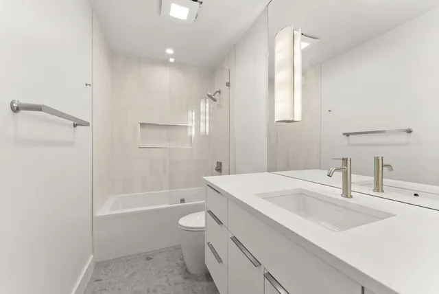 a bathroom with a sink a toilet and shower