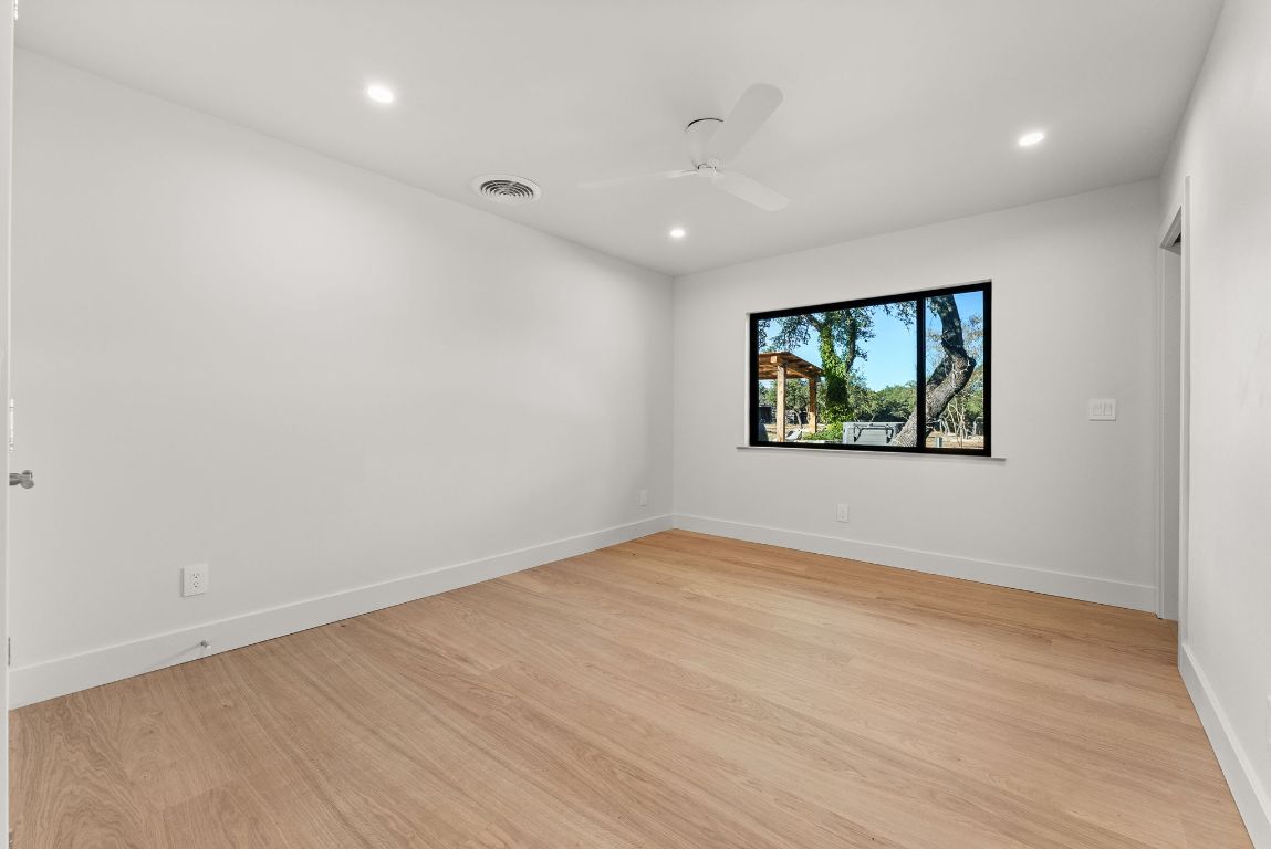 8717 South View Road Austin, TX 78737 - Photo 25 of 38 an empty room with wooden floor and window