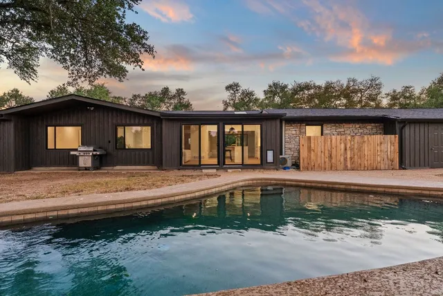 a view of a house with backyard and sitting area