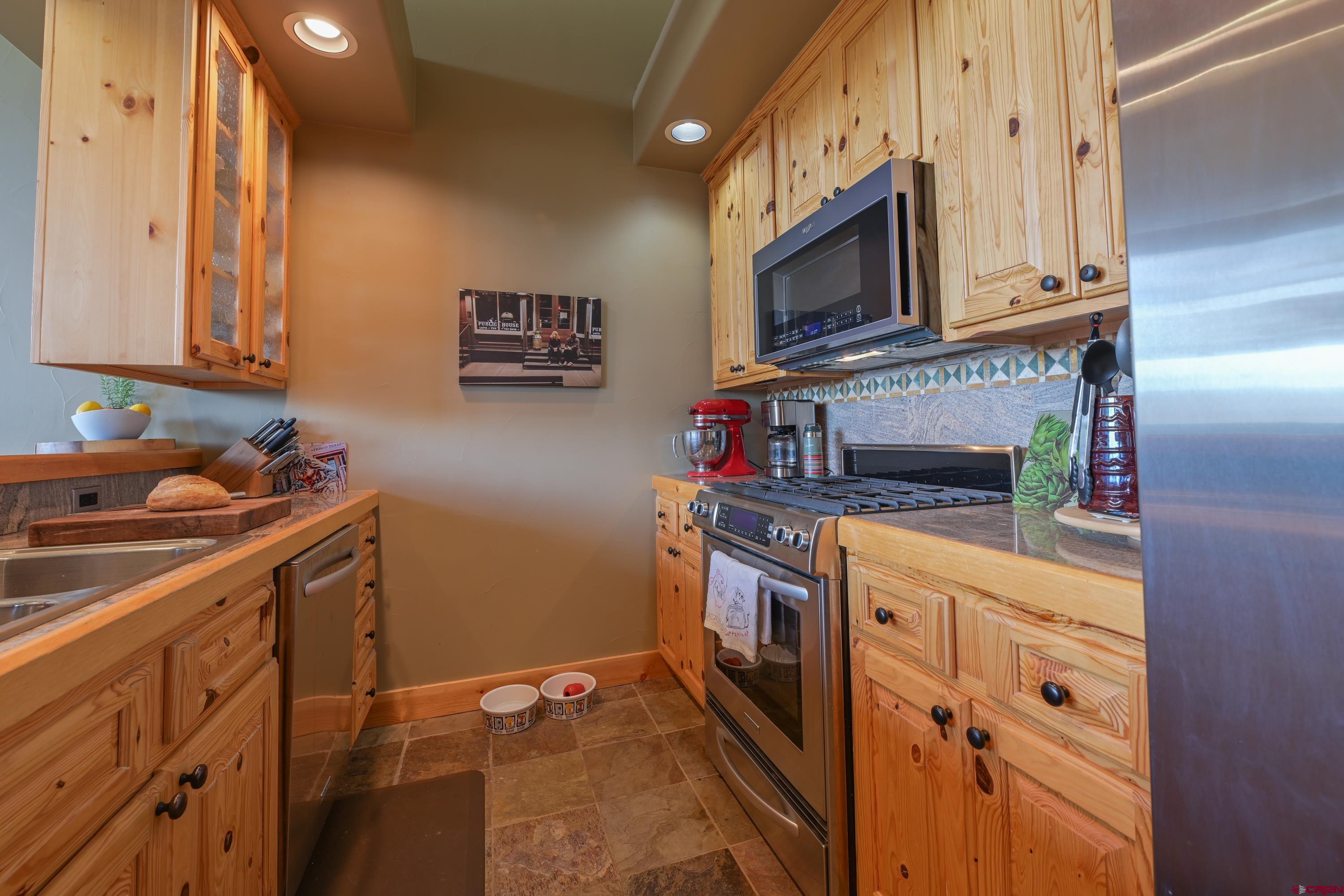 32 St Andrew's Circle Crested Butte, CO 81224 - Photo 18 of 35 a kitchen with stainless steel appliances granite countertop a sink stove and microwave