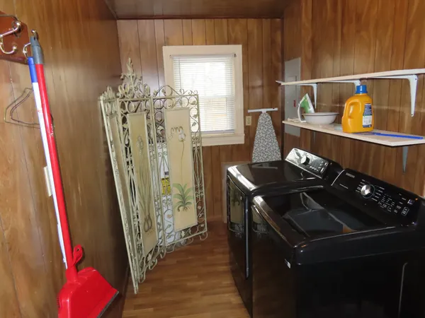 a kitchen with a sink a refrigerator and a wooden floor