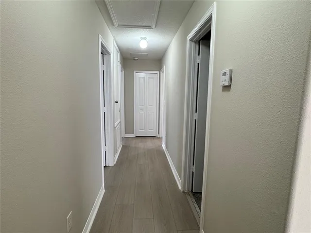 a view of a hallway with wooden floor