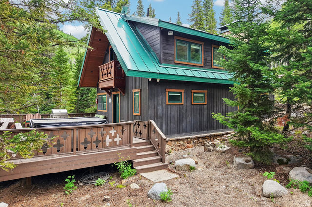 10205 East Moose Loop Road Salt Lake City, UT 84121 - Photo 3 of 50 Rustic-inspired exterior with dark wood siding and a vibrant green metal roof