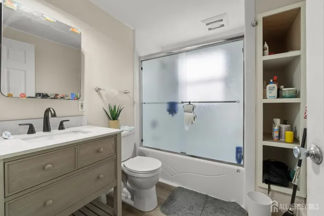 a bathroom with a granite countertop sink toilet and shower