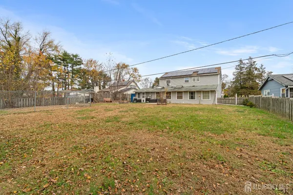 a view of house with yard and trees in the background
