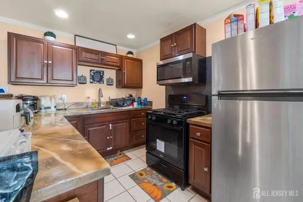 a kitchen with granite countertop a refrigerator stove and sink