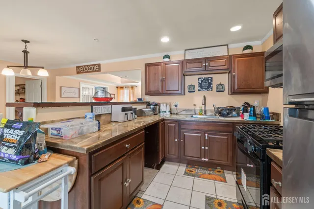 a kitchen with stainless steel appliances granite countertop a stove top oven a sink dishwasher and cabinets with wooden floor