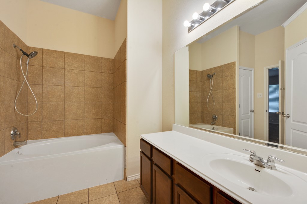 291 Cold Spring Buda, TX 78610 - Photo 14 of 25 a bathroom with a sink mirror toilet and bathtub