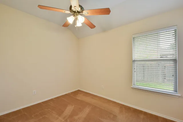 an empty room with a window and a fan