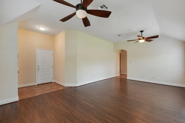 an empty room with wooden floor a ceiling fan and closet