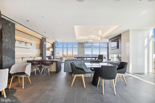 a view of a patio with couches and table and chairs with wooden fence and large trees