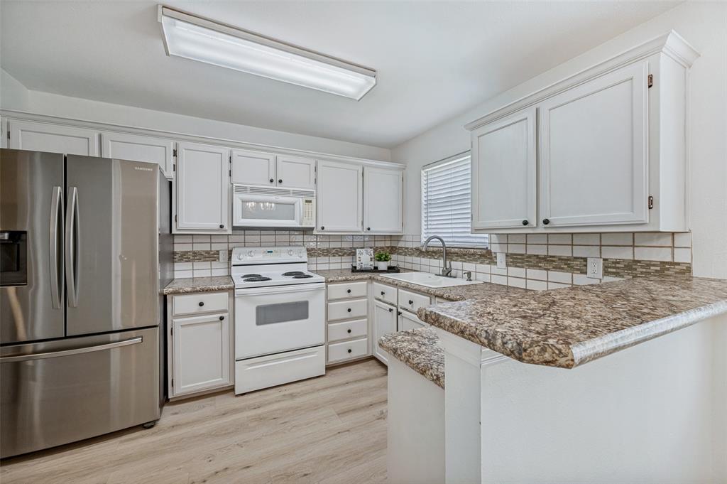 629 Concho Drive Oak Point, TX 75068 - Photo 10 of 35 a kitchen with white cabinets and stainless steel appliances