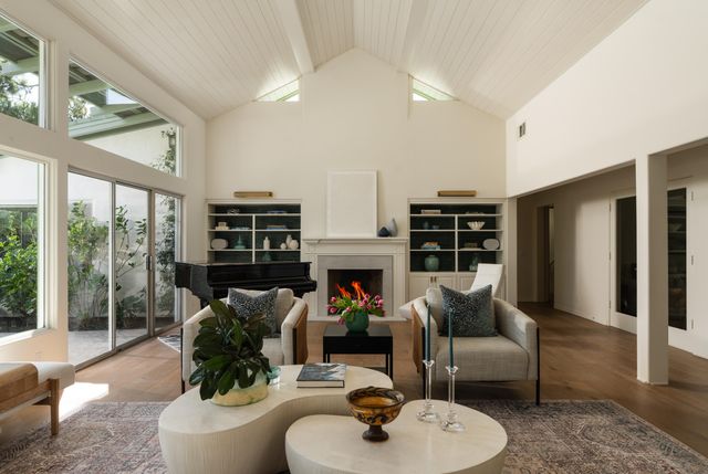 a living room with furniture a fireplace and a large window