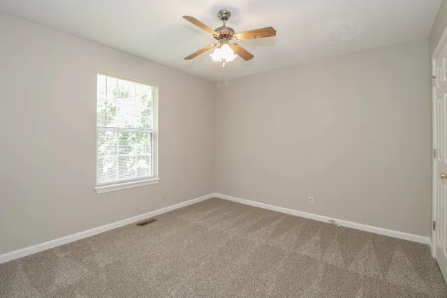 an empty room with closet and fan