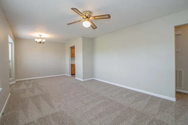 an empty room with closet and a ceiling fan