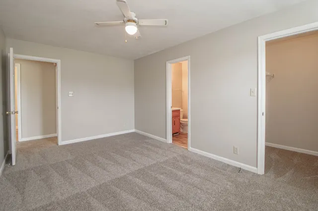 an empty room with a window and ceiling fan