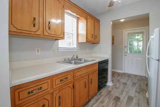 a kitchen with granite countertop a sink cabinets stainless steel appliances and a window