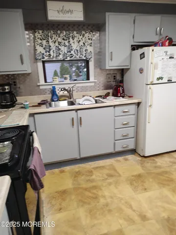 a kitchen with granite countertop a sink stove and cabinets