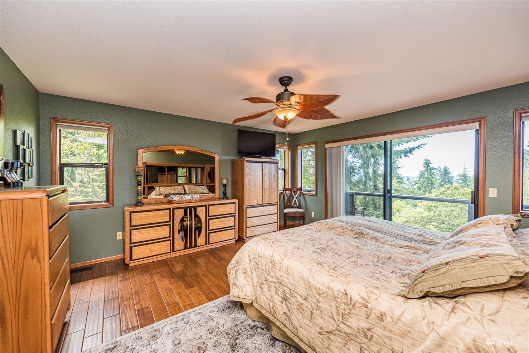 1313 Doe Run Road Sequim, WA 98382 - Photo 17 of 40 a bedroom with a large bed a flat tv screen and a dresser