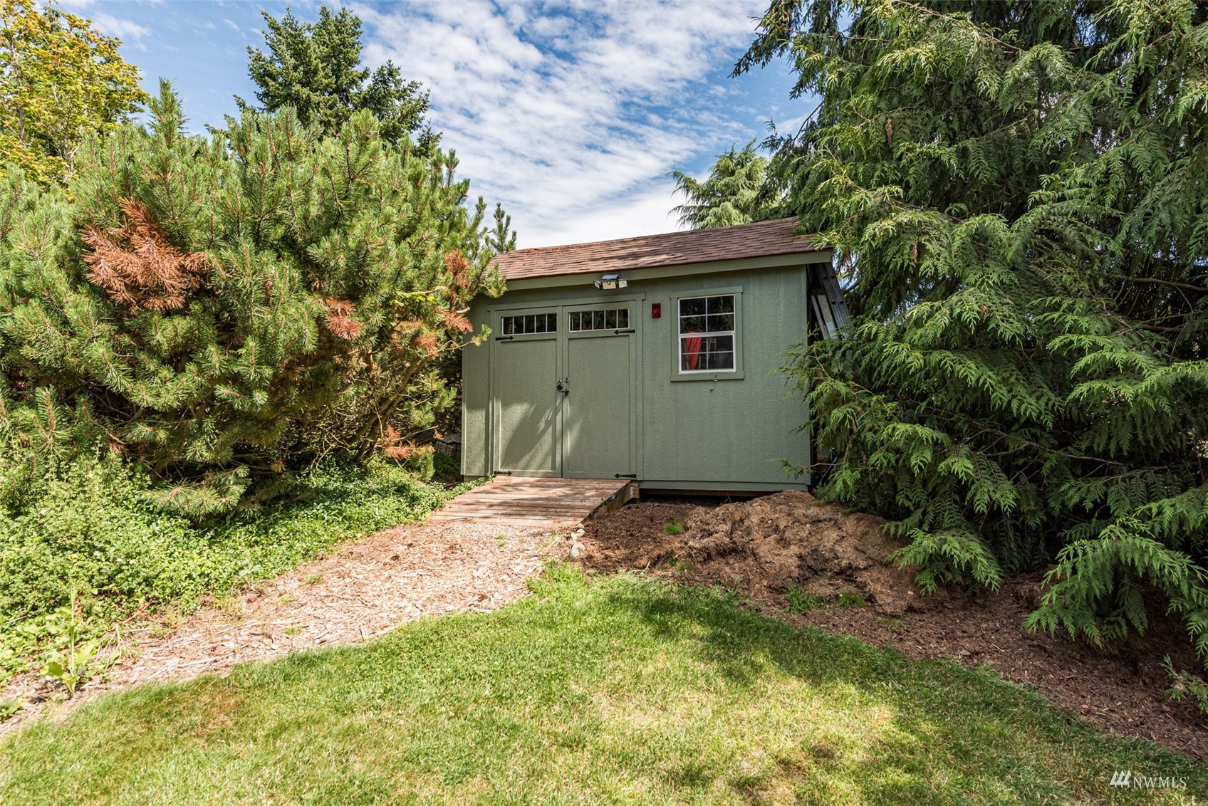 1313 Doe Run Road Sequim, WA 98382 - Photo 32 of 40 a backyard of a house with plants and trees