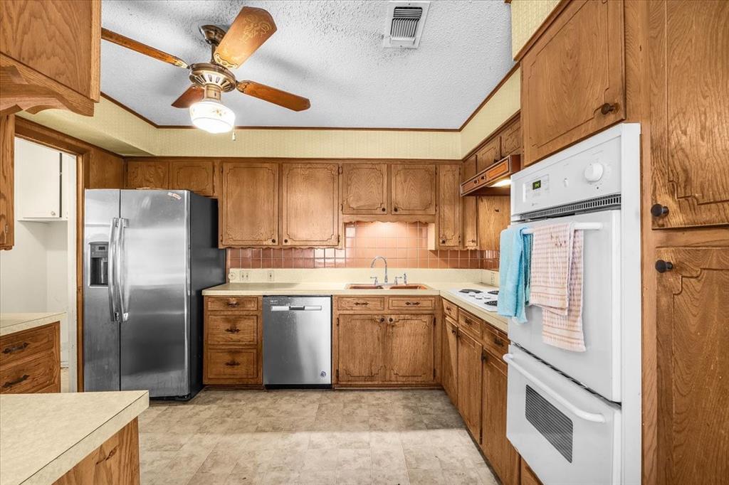 601 State Street Weatherford, TX 76086 - Photo 11 of 38 a kitchen with stainless steel appliances granite countertop a refrigerator a sink a stove with cabinets