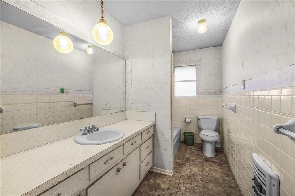 601 State Street Weatherford, TX 76086 - Photo 17 of 38 a bathroom with a sink a toilet and a mirror