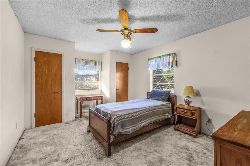 601 State Street Weatherford, TX 76086 - Photo 18 of 38 a bedroom with a bed and a chandelier