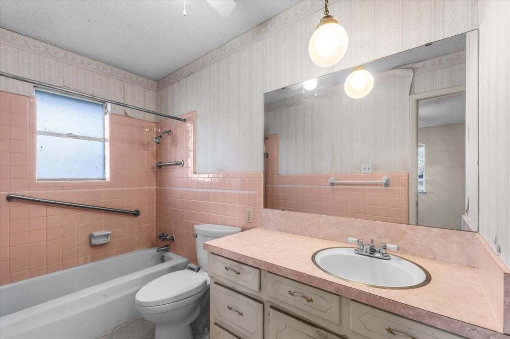 601 State Street Weatherford, TX 76086 - Photo 22 of 38 a bathroom with a granite countertop sink toilet a mirror and shower