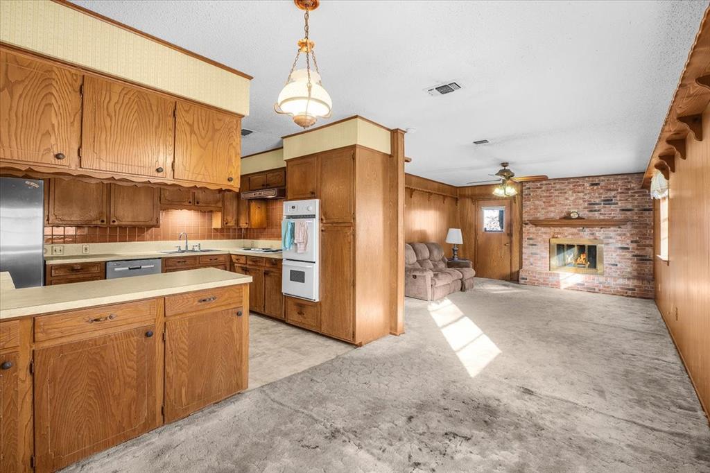 601 State Street Weatherford, TX 76086 - Photo 9 of 38 a open kitchen with cabinets a refrigerator and a stove